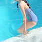 ブルーのワンピース水着を横向きで着用。サイドラインとヒップまわりの見え方が分かる写真