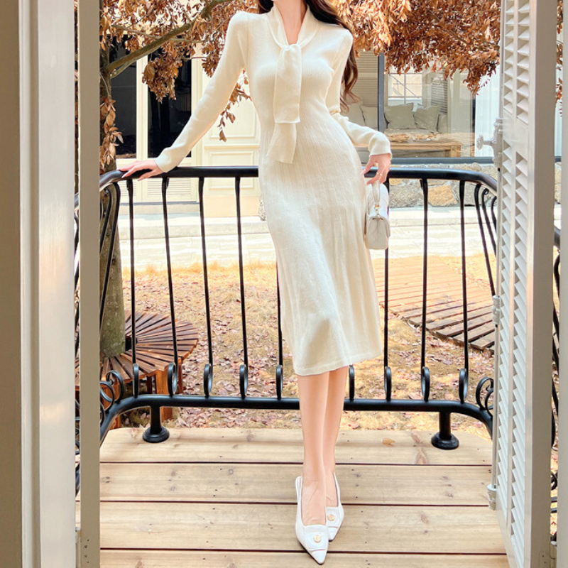 バルコニーで白のニットワンピースを着る女性｜大人可愛いデートファッション