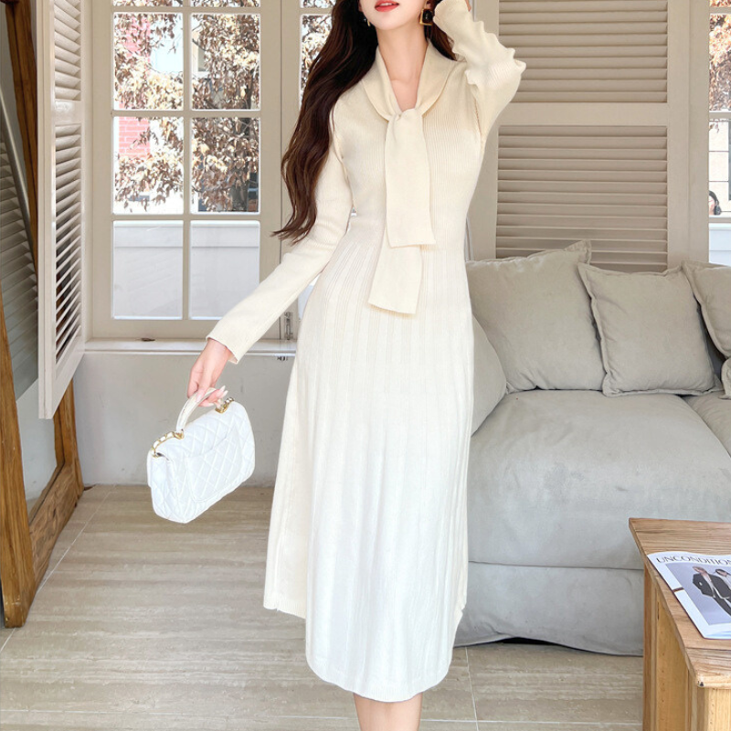 窓際でリボンタイワンピースを着る女性｜上品で落ち着いた大人のデート服