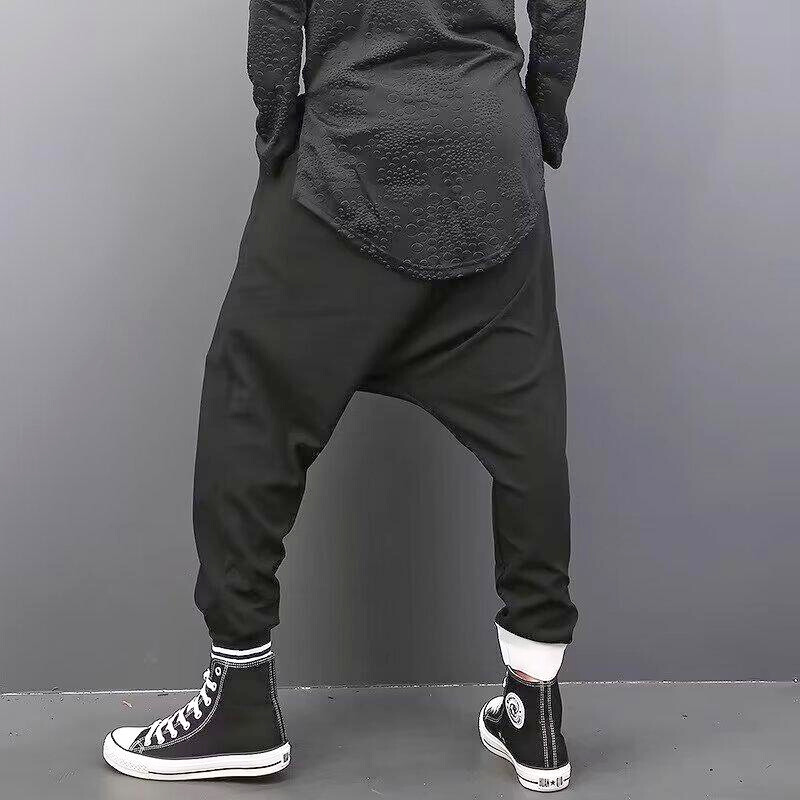 黒のアシンメトリーサルエルジョガーパンツを後ろから見せたメンズバックスタイル画像