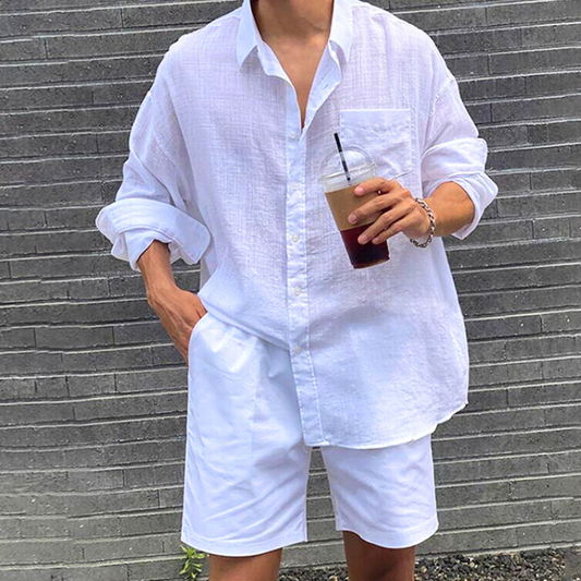 長袖をロールアップした綿麻白シャツを着用したメンズ夏コーデ画像