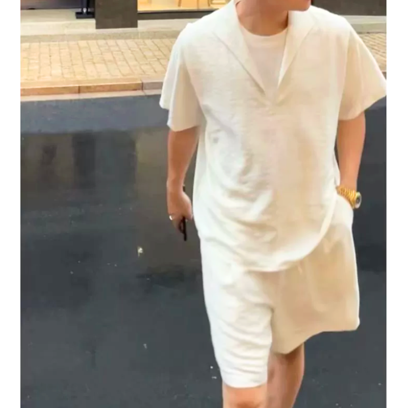 深V開襟のリネンセットアップ（ホワイト）を着たメンズの街歩きイメージ