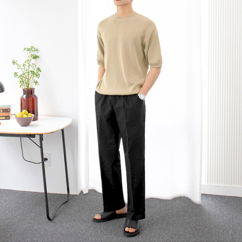 ベージュトップスに合わせたブラックのストレートパンツ