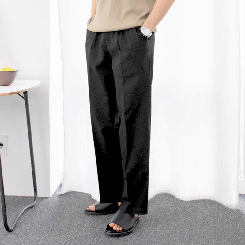 ブラックパンツとベージュトップスでナチュラルな立ち姿