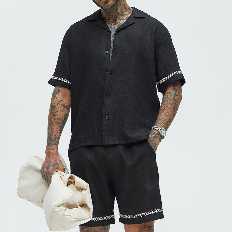 ブラックの配色ライン開襟半袖シャツ＆ショートパンツセットアップを着用した大人メンズ夏コーデ画像