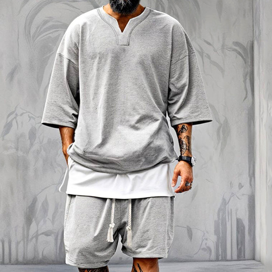 Vスリット5分袖スウェットトップスとショートパンツのグレーセットアップを着用したメンズ正面画像