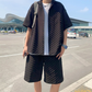 黒のセットアップを着た男性が空港の外でリラックスしたポーズ