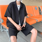 凹凸セットアップの黒を着た男性が駅の待合室に座っている