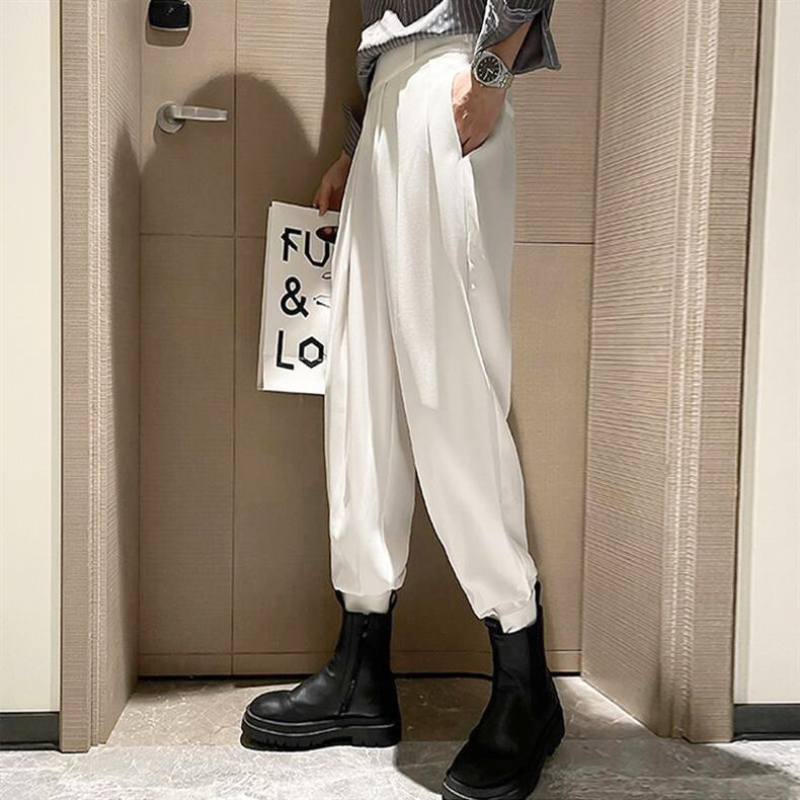 脚をやや開いた状態で白ジョガーの裾を見せる写真