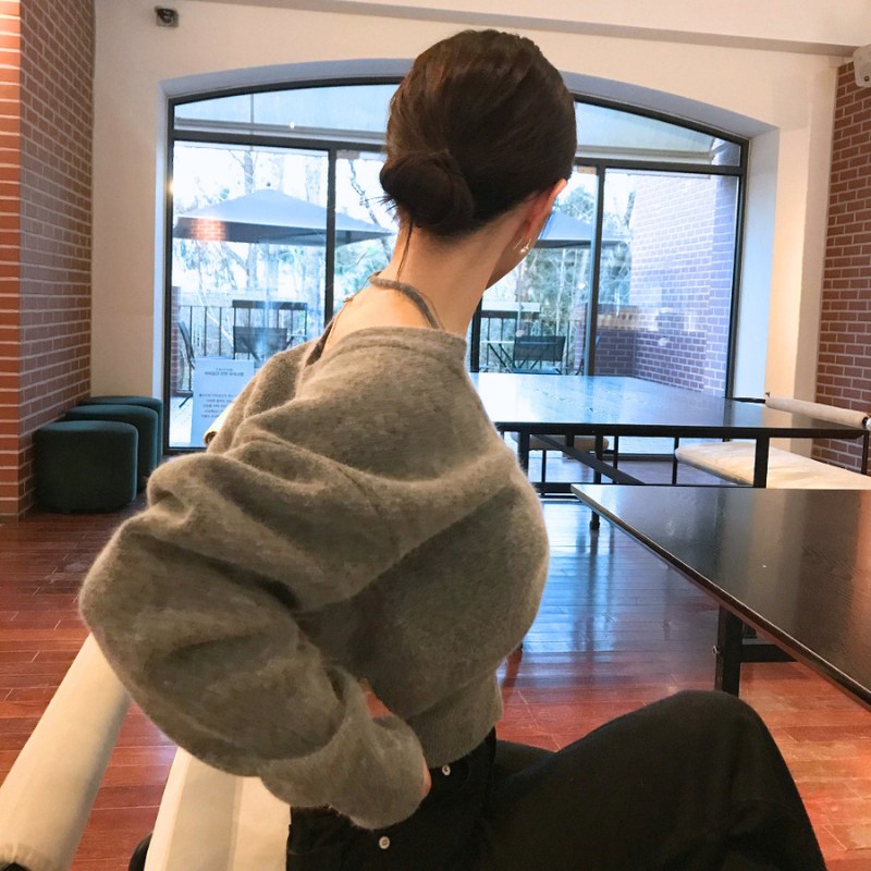 グレーのふんわりニットトップスを後ろから見せた着用画像