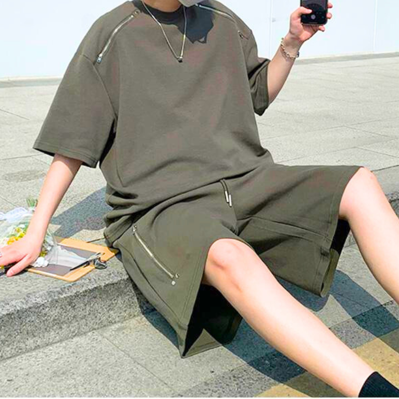 屋外で座っているカーキセットアップ姿の男性