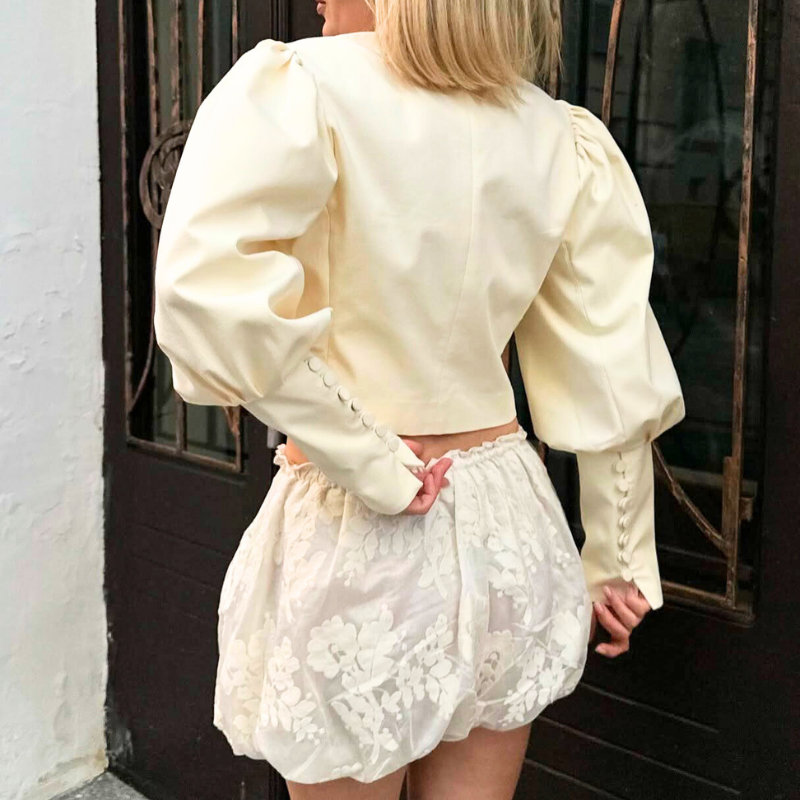 パフスリーブブラウスをレース風ショートボトムに合わせた華やかなコーデイメージ