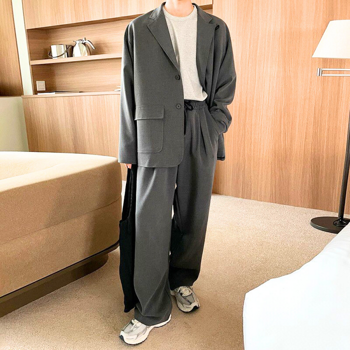 グレーセットアップを着こなす男性｜ドローコード付きジャケットとワイドパンツ