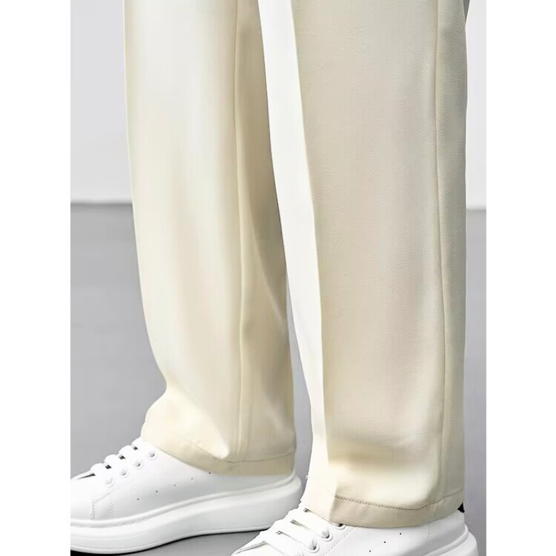 ベージュロングパンツの裾まで上品に仕上げられたディテール