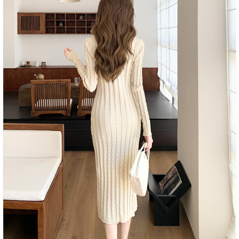 アイボリーのVネックケーブルニットワンピースを歩く姿で見せた着用イメージ（後ろ姿）