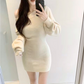 鏡越しの白ニットワンピース姿。ミニ丈が可愛さを引き立てる。