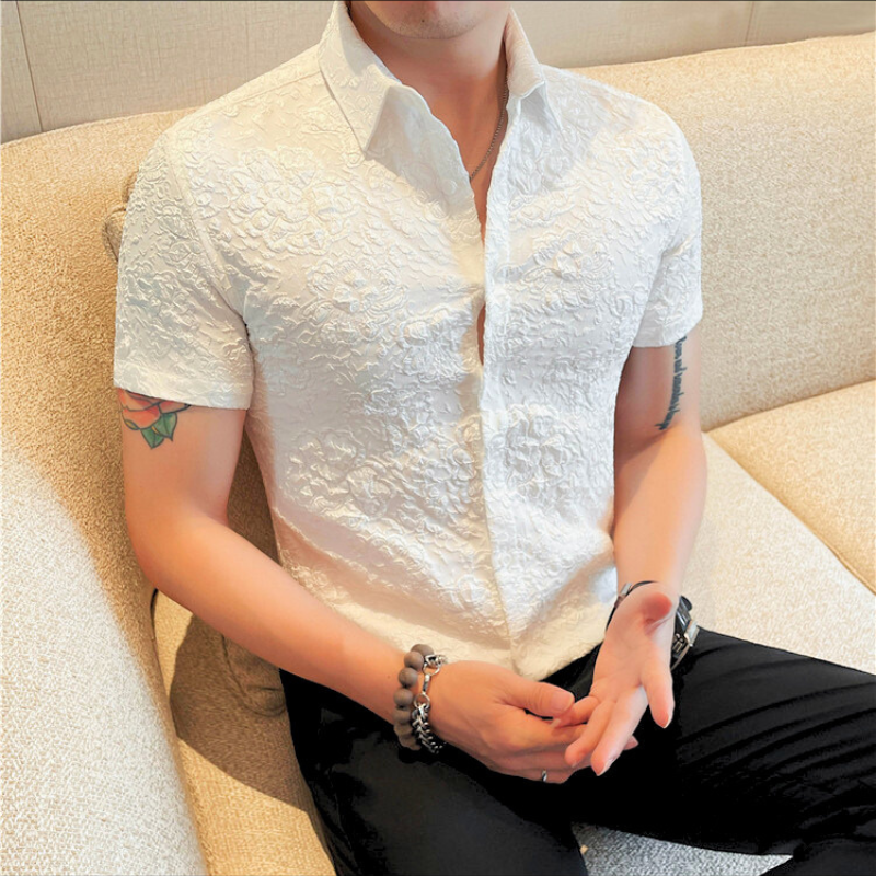 白シャツの男性がやや斜めを向いてポージングしている