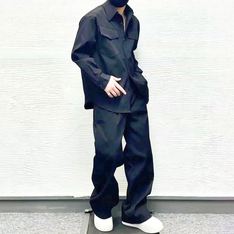 ブラックのセットアップを着こなす男性の斜めショット