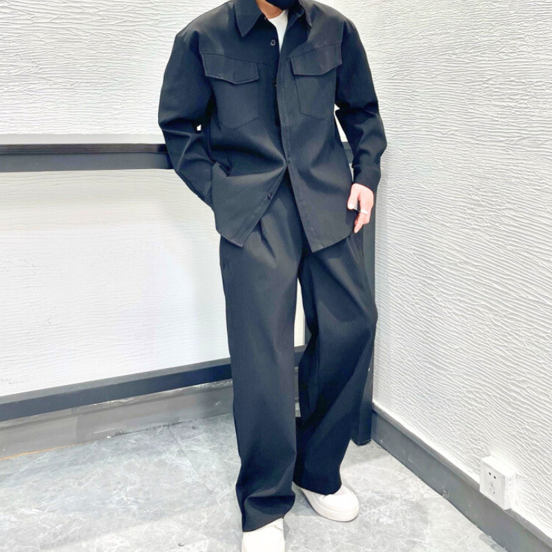 ブラックのセットアップを正面から立って着こなす男性