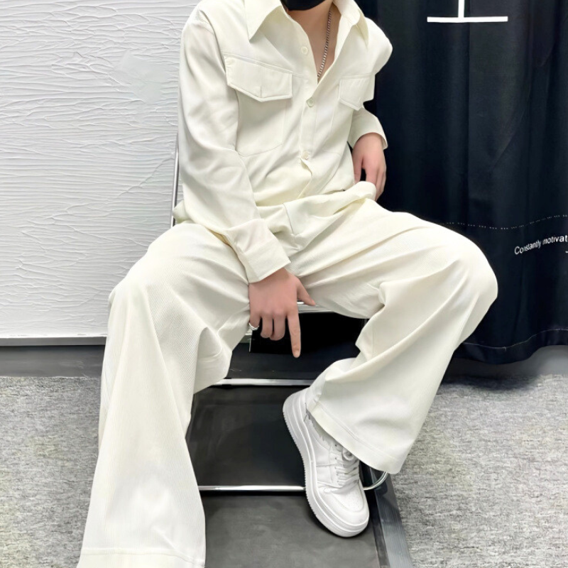 アイボリーのセットアップを座ったスタイルで着用