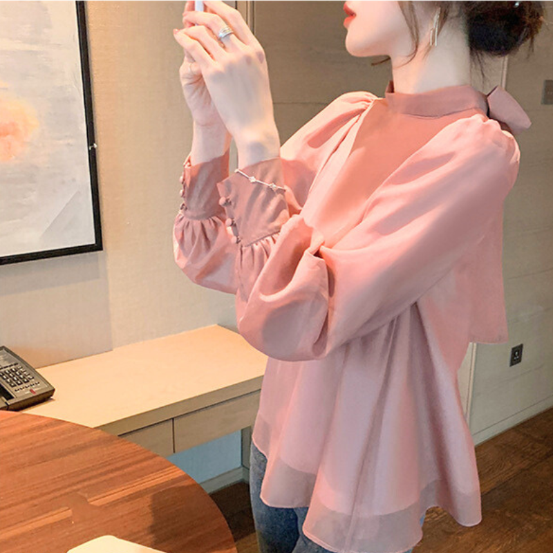 ピンクのバックリボンシフォンブラウスを着た女性 春秋デート服にぴったりの上品コーデ